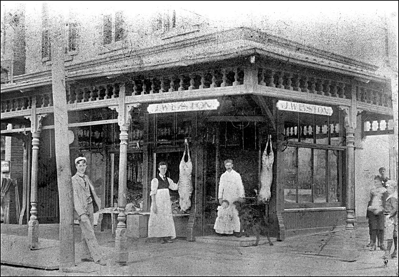 Joseph W. Weston (behind his daughter Ann Fern Weston) butcher shop 1896, Carlton St., n.w. co...jpg
