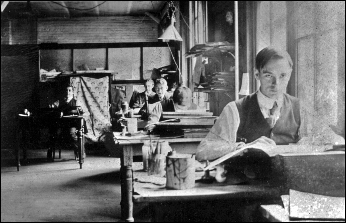 Tom Thomson as a graphic artist at Grip Limited; J.E.H. MacDonald seen in background at end of...jpg