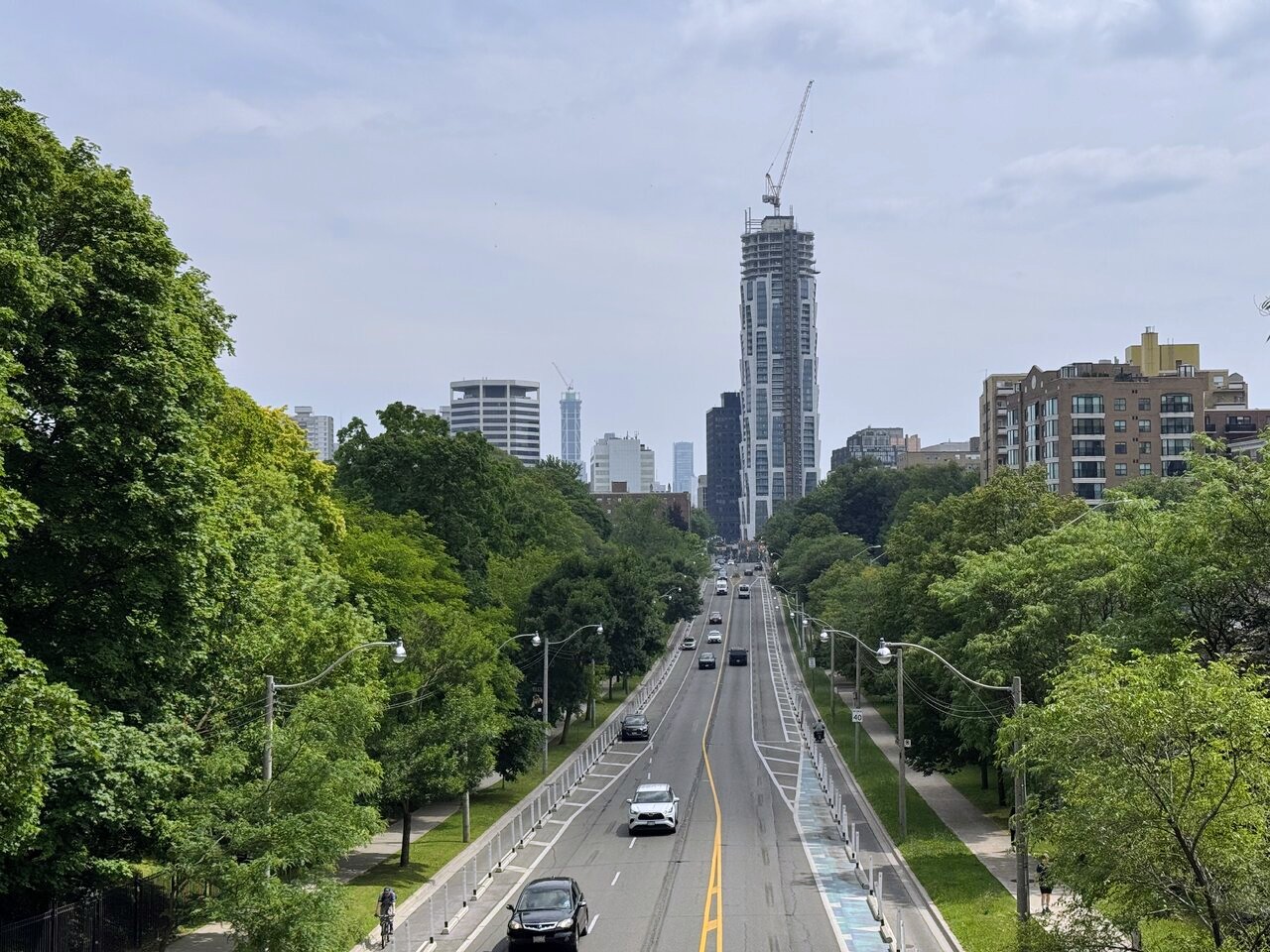 Distant view of One Delisle rising above Toronto with its rotating tower profile
